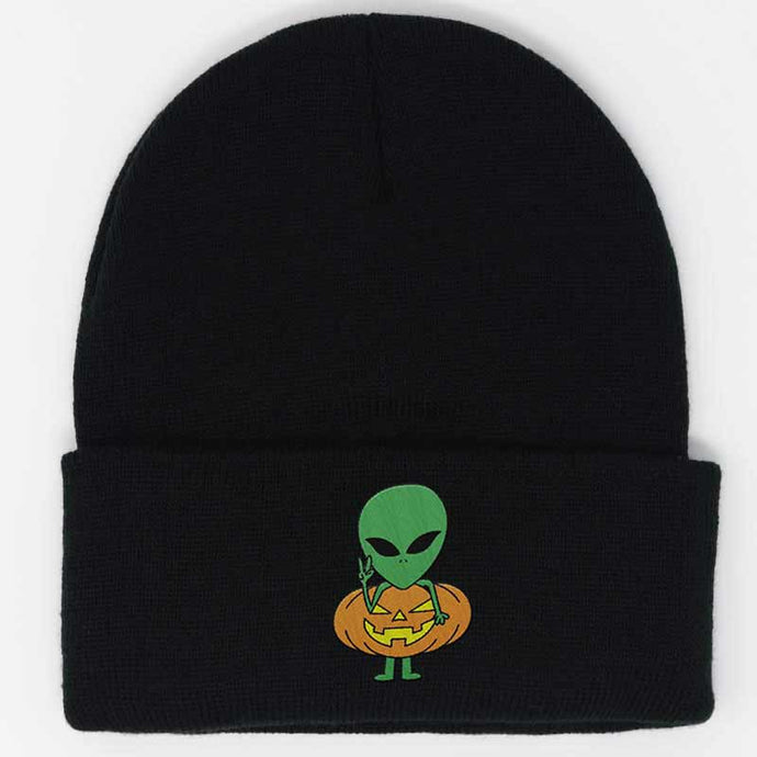 green alien wearing a pumpkin costume embroidered on a black beanie